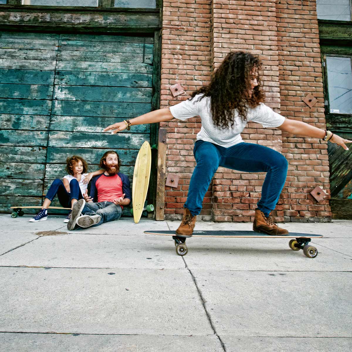 Eine Skaterin bewegt sich lachend und unbeschwert auf ihrem Skateboard.